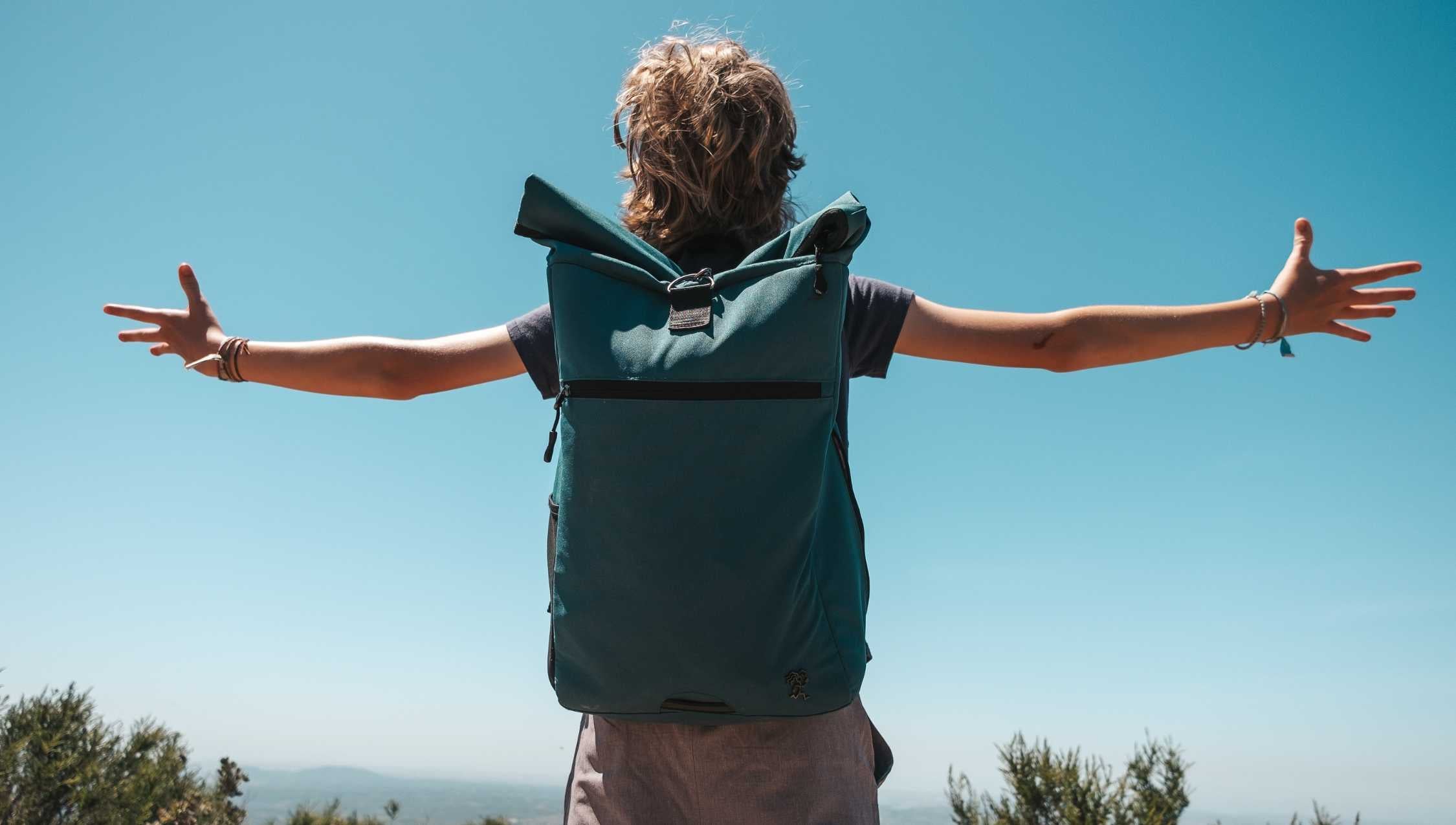 Ein Junge, der den petrolfarbenen PIET Rucksack traegt, steht am Grand Canyon und schaut auf die Berge