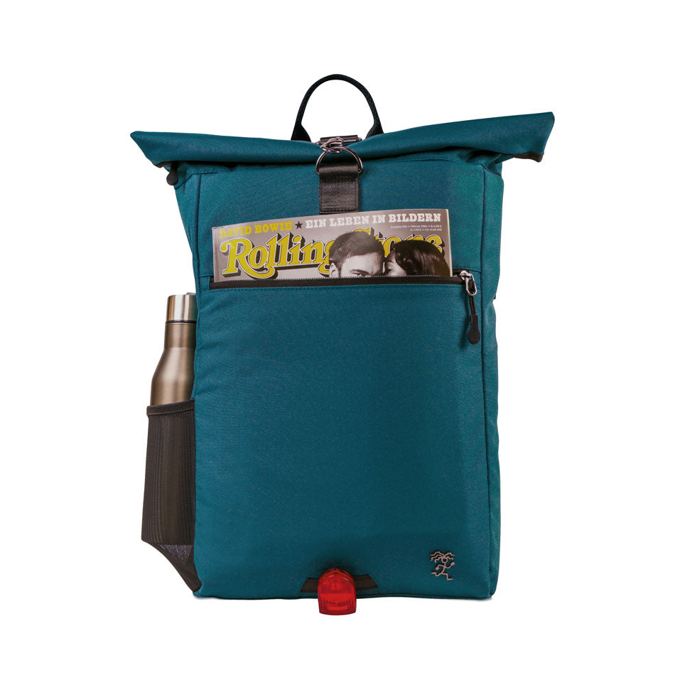 Vorderansicht des bepackten petrolblauen FUCHS und REBELL PIET Rolltop Rucksacks mit Regenschirm und Zeitschrift.
