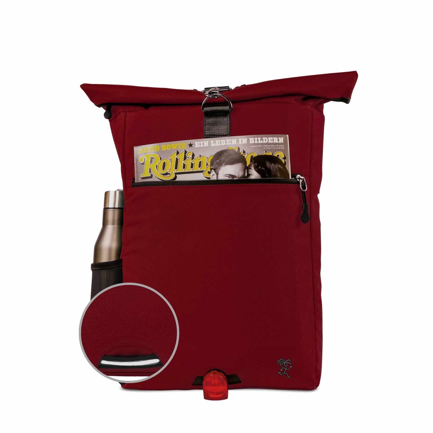 Vorderansicht des bepackten FUCHS und REBELL PIET Rolltop Rucksacks in rot mit Thermoflasche, Magazin und reflektierendem Riemen auf der Vorderseite.